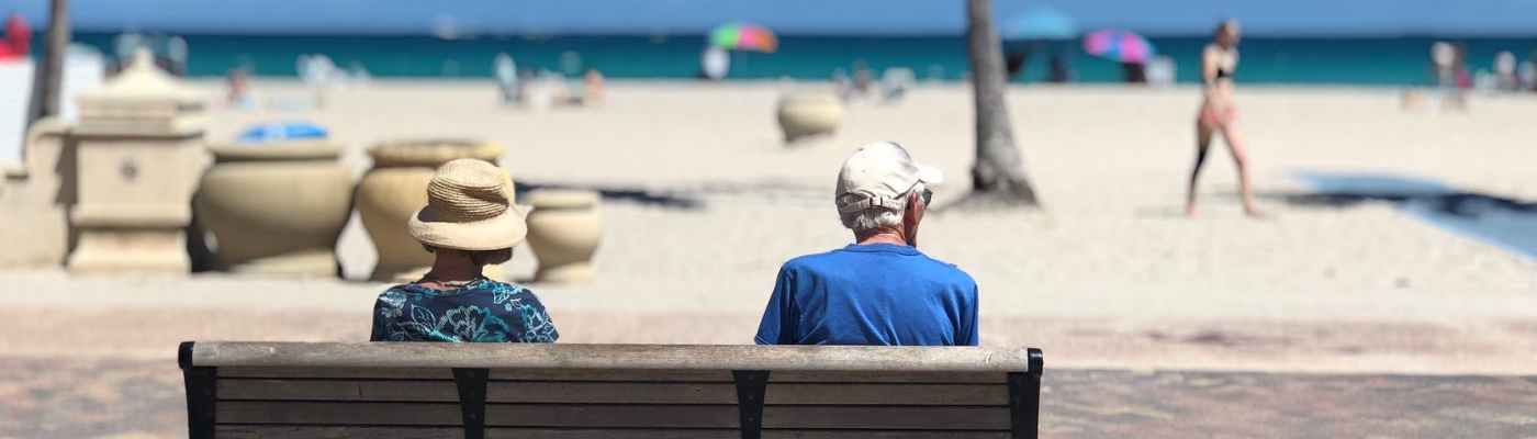 man and woman sitting on brown wooden bench