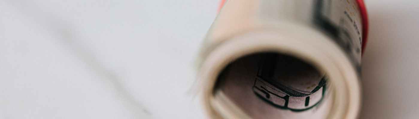 american dollar banknotes rolled and tightened with red band