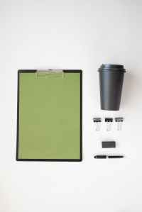 coffee cup and stationery items on white surface