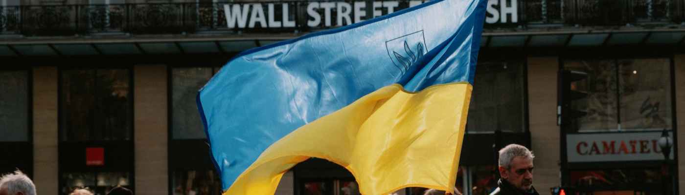 blue and yellow ukrainian flag waving above crowd of people