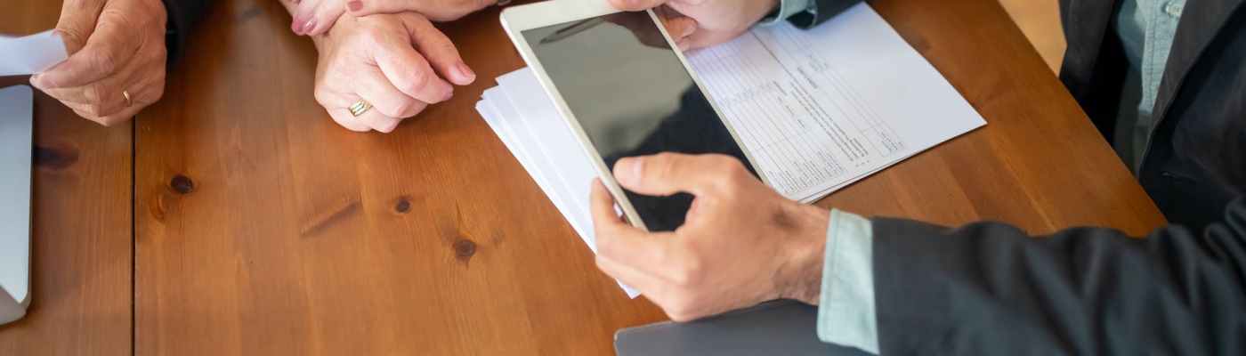 person in black suit holding white digital tablet