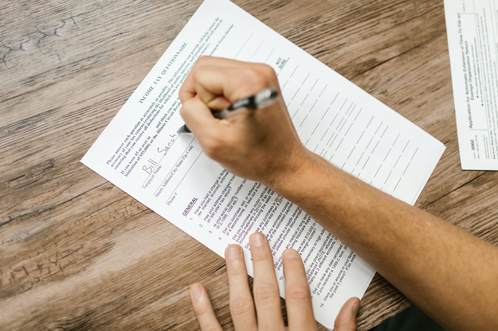 close up shot of a person filling out a questionnaire