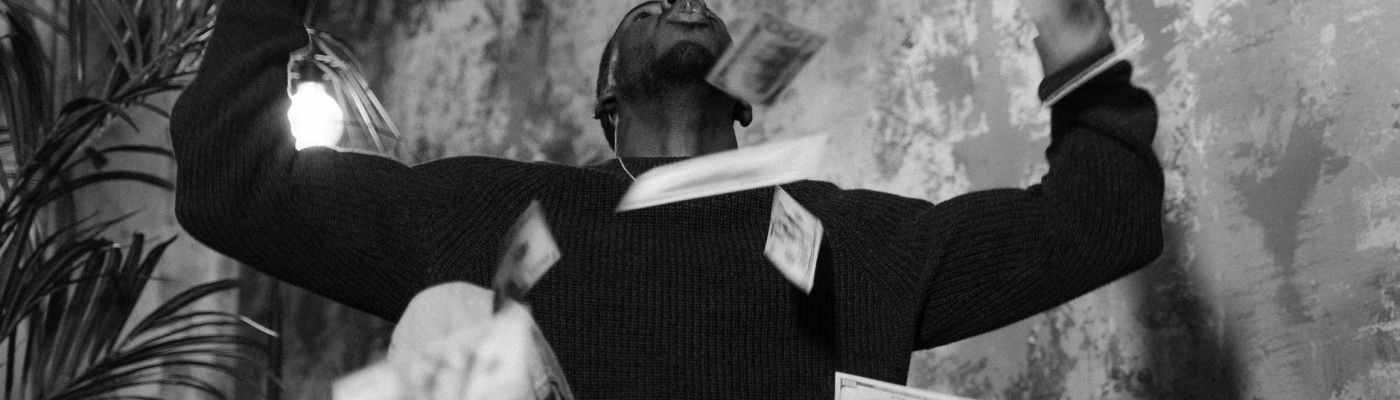 man in black long sleeve shirt and gray pants sitting on chair