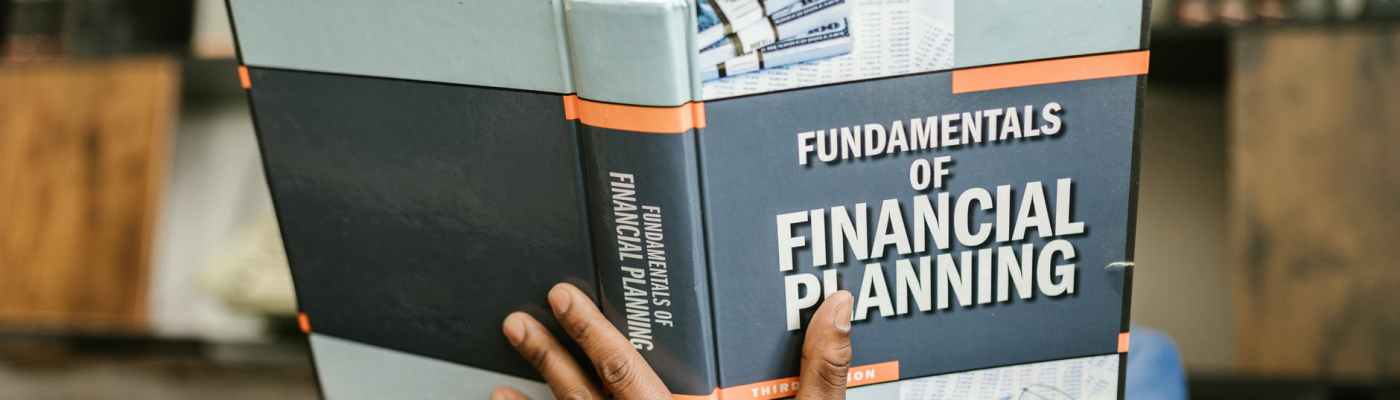 person reading a book about fundamentals of financial planning